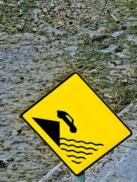 Close-up of yellow sign on water