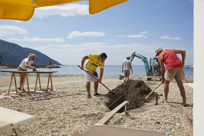 People at beach against sky