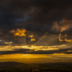 Scenic view of dramatic sky over landscape during sunset