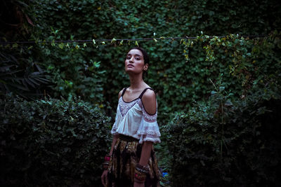 Woman standing by tree in forest