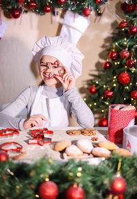 Portrait of young woman holding christmas tree