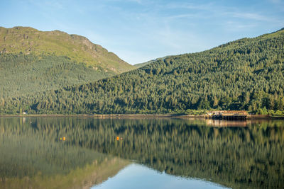 Scenic view of lake by mountains against sky