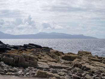 Scenic view of sea and mountains against sky