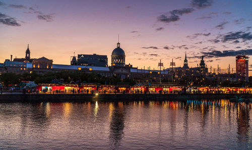 River in city against sky during sunset