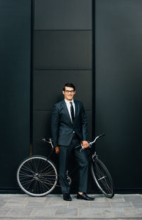 Full length portrait of young man with bicycle