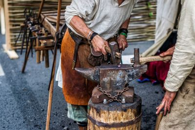 Low section of blacksmiths working in workshop