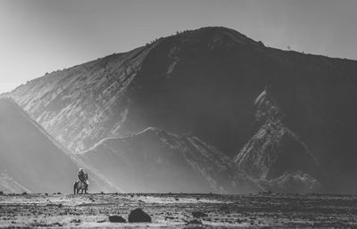 Man riding horse against mountains