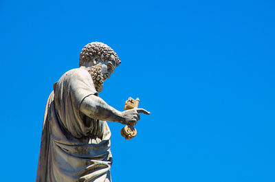 Low angle view of statue against clear blue sky