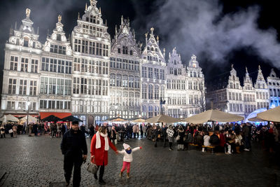 Crowd at town square against sky at night