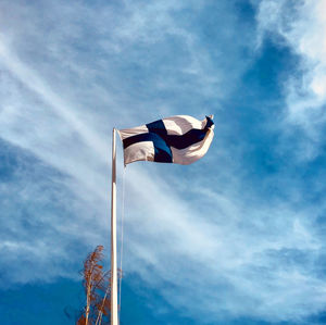 Low angle view of flag against blue sky