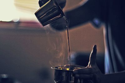 Cropped image of hand pouring coffee in bowl