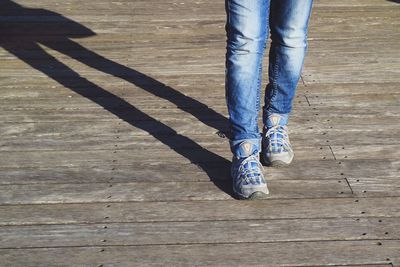 Low section of woman standing on wooden floor