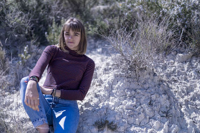 Portrait of young woman standing in forest