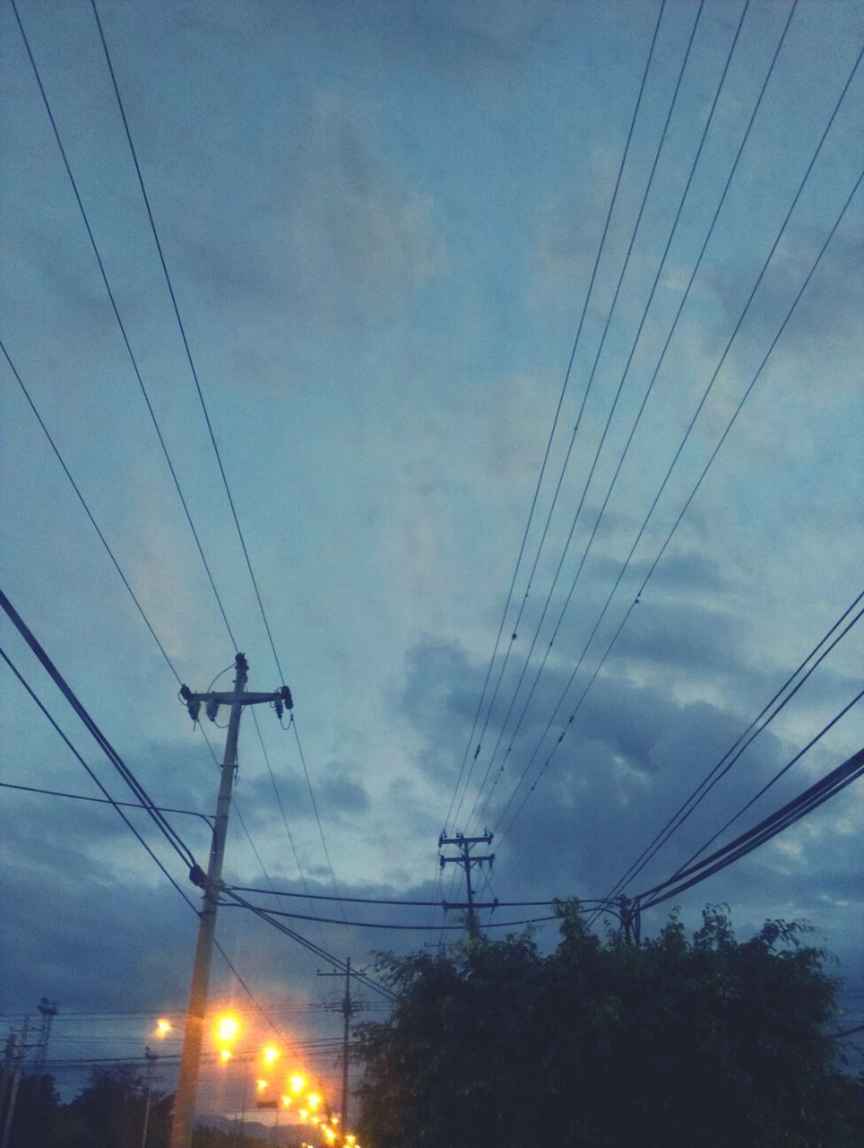 power line, electricity pylon, electricity, power supply, cable, low angle view, connection, sky, fuel and power generation, technology, power cable, cloud - sky, silhouette, complexity, cloudy, dusk, blue, no people, outdoors, lighting equipment