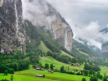 Scenic view of foggy landscape with waterfall