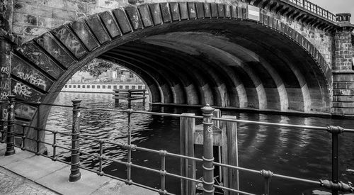 Arch bridge over river against building