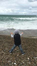 Rear view of person looking at sea shore