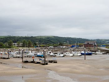 Boats moored on beach against sky