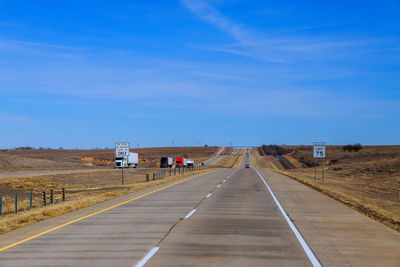 Road amidst landscape against blue sky