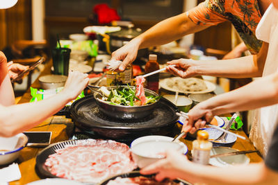 Group of friends cooking the chinese shabu hotpot at home.