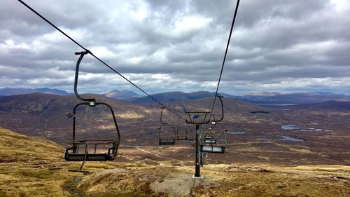 Overhead cable car in mountains against sky