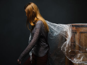 Woman standing against black background