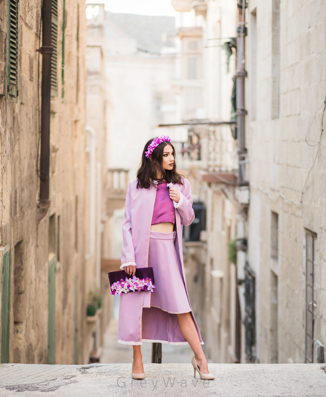 WOMAN WITH PINK UMBRELLA IN CITY AGAINST BUILDING