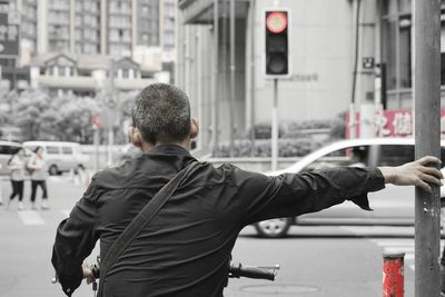 Man holding umbrella on street in city