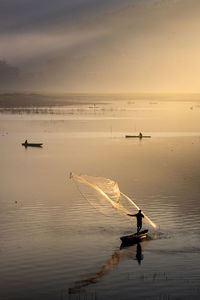 Men fishing on the lake during sunrise