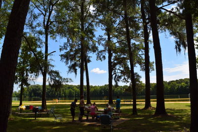 People sitting at park against sky