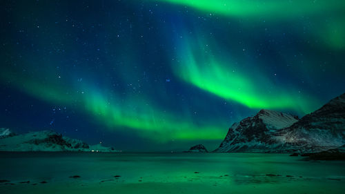 Scenic view of snowcapped mountains against sky at night