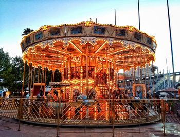 Illuminated ferris wheel against sky