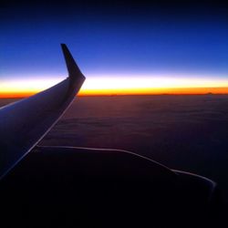 Cropped image of airplane flying over clouds
