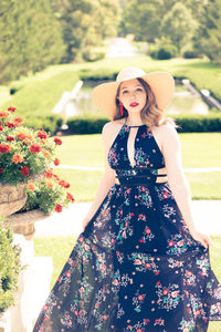 Portrait of woman wearing hat standing in park