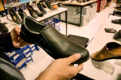 Man choosing leather shoes in a shopping mall