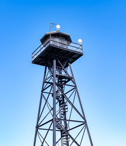 Low angle view of communications tower against clear blue sky