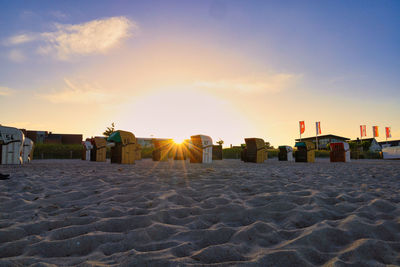 Buildings at beach against sky during sunset