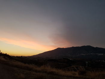 Scenic view of silhouette mountains against sky during sunset