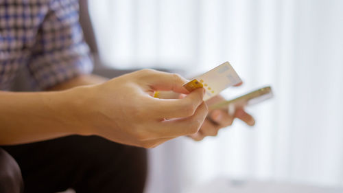 Midsection of man using mobile phone