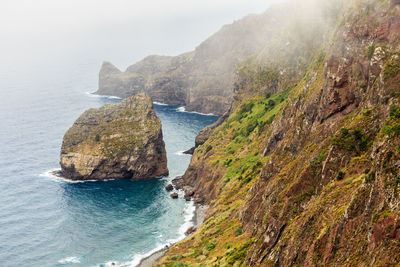 Scenic view of sea and mountains against sky