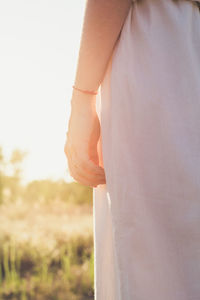 Close up sunlight glare falling on female wrist with red thread concept photo