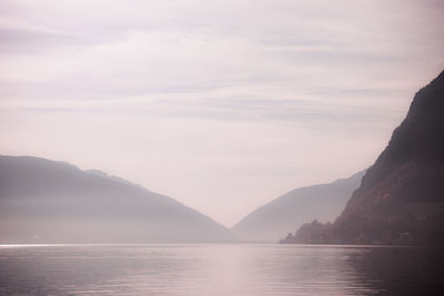 Scenic view of sea and mountains against sky