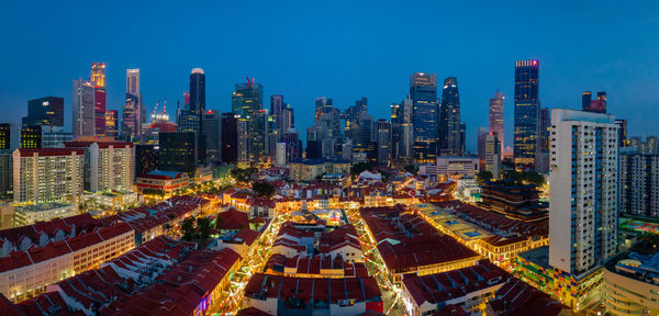 Aerial view of illuminated buildings in city against clear sky