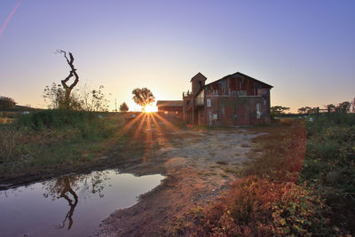 House by building against sky during sunset