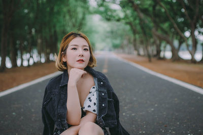 Portrait of woman sitting on road