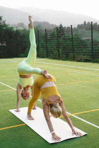 Side view of woman exercising on field