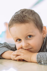 Close-up portrait of cute girl sitting on bed at home