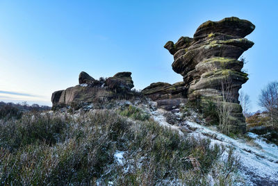 Rock formation on land against clear sky