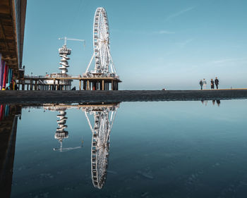 Reflection of tower on sea against sky