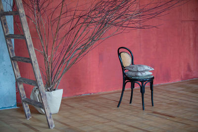 Empty chair on table against wall in building